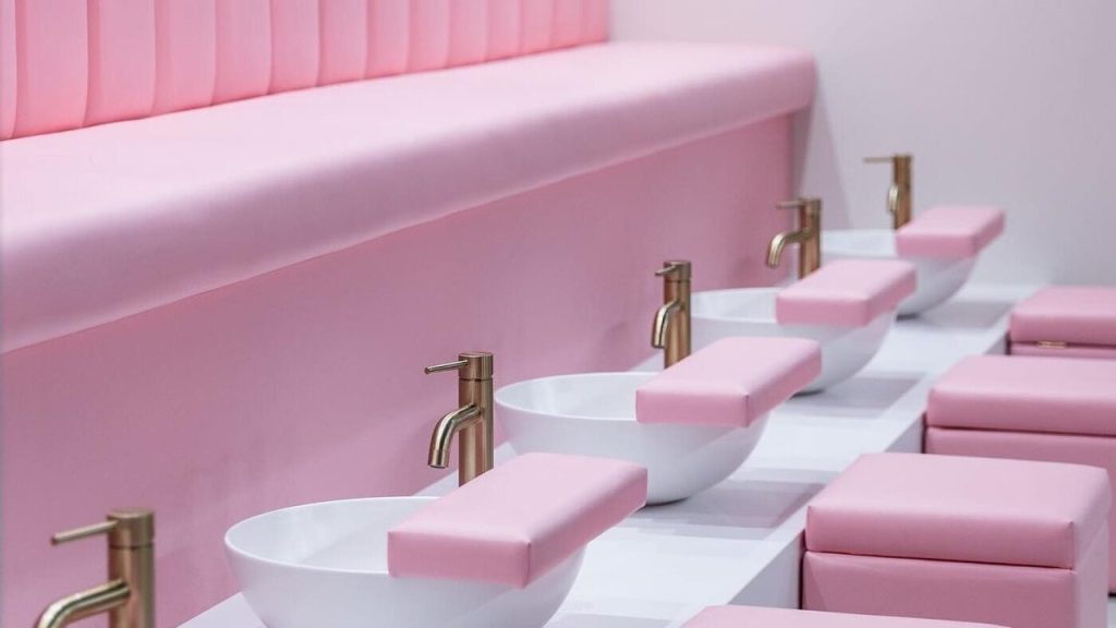 Pink pedicure stations with gold taps